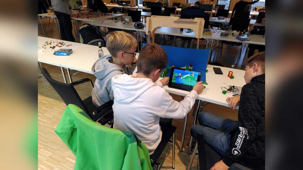 Kinder bauen Szenen aus Lego-Steinen für einen Stop-Motion-Film