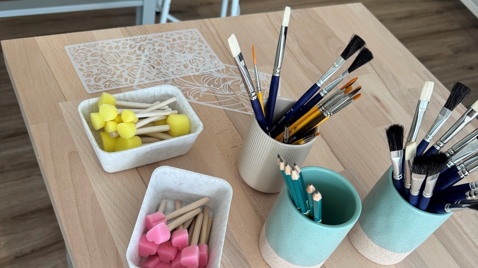 Arbeitstisch in der Keramikinsel Lingen mit Pinseln, Stupfschwämmchen und Schablonen zum Bemalen von Keramik