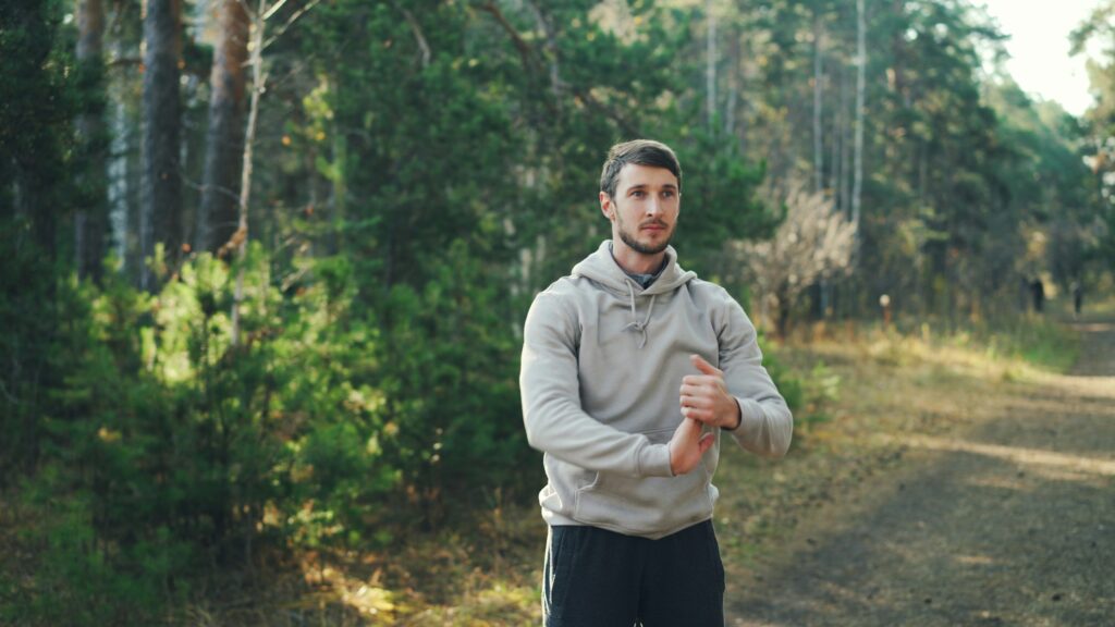 Mann dehnt sich bei einer Pause im Wald