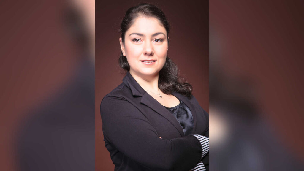 Porträt der Pianistin Susanna Kadzhoyan mit verschränkten Armen vor dunklem Hintergrund