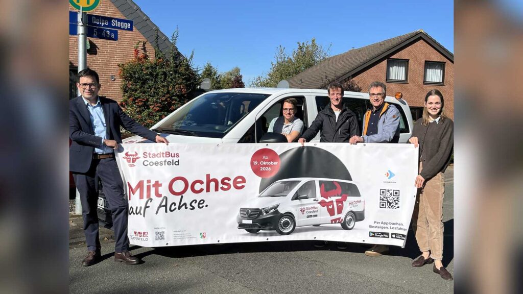 Vertreter der Stadt Coesfeld und des Anbieters CleverSolutions stellen mit einem Banner den neuen StadtBus Coesfeld vor