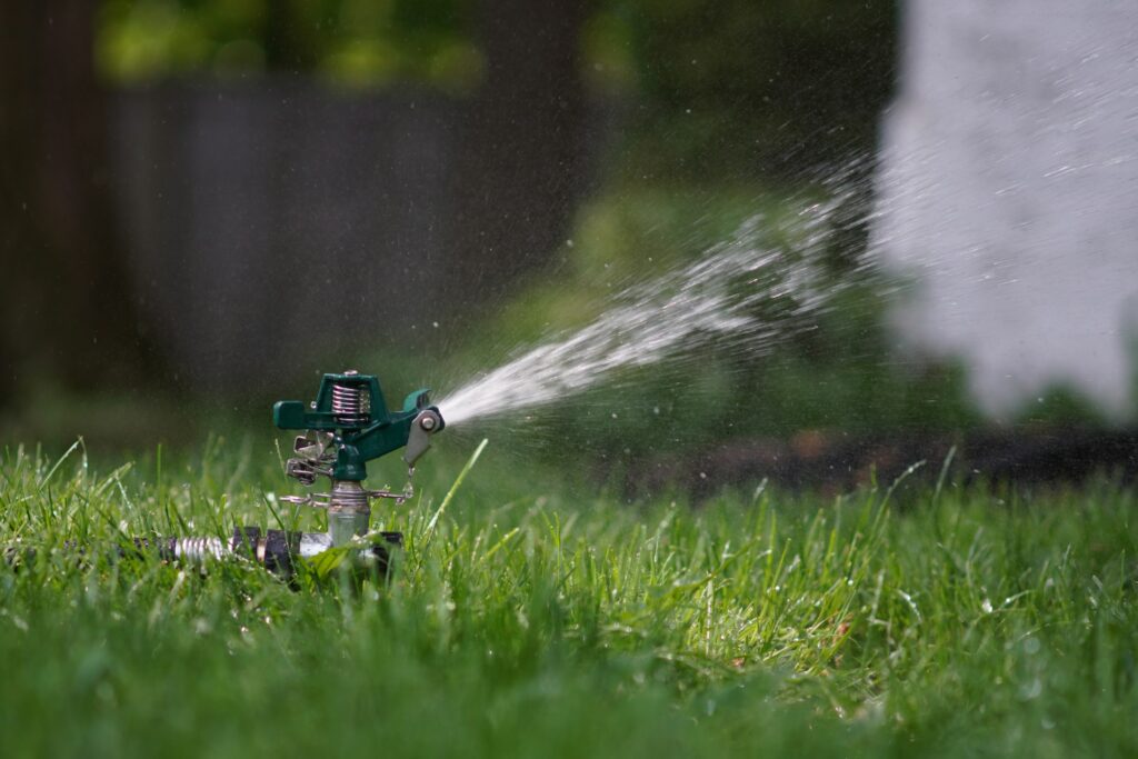 Rasensprenger bewässert eine Rasenfläche im Garten