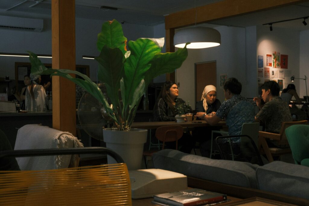 Mehrere Menschen sitzen bei Kaffee an einem Tisch und unterhalten sich