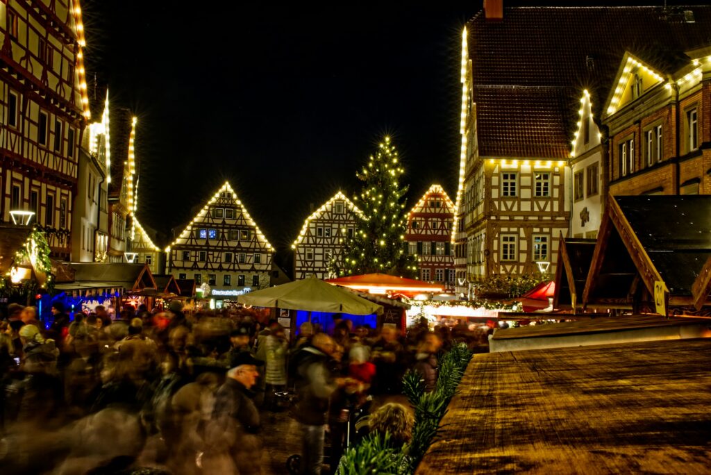 Beleuchtete Holzbuden auf einem Weihnachtsmarkt am Abend