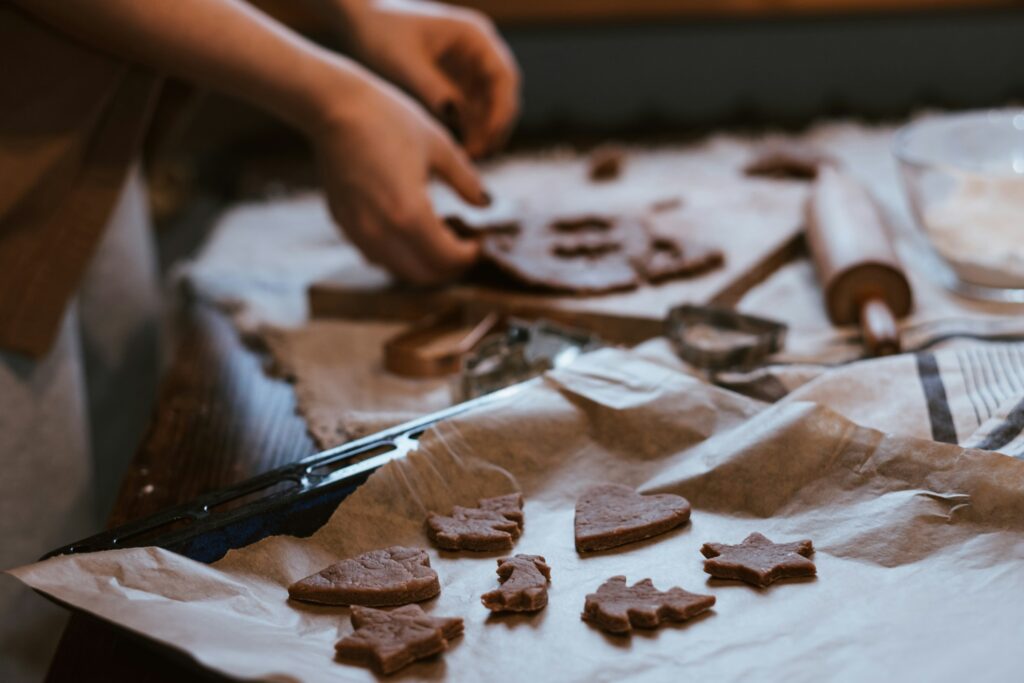 Hände stechen Weihnachtsplätzchen aus ausgerolltem Teig aus