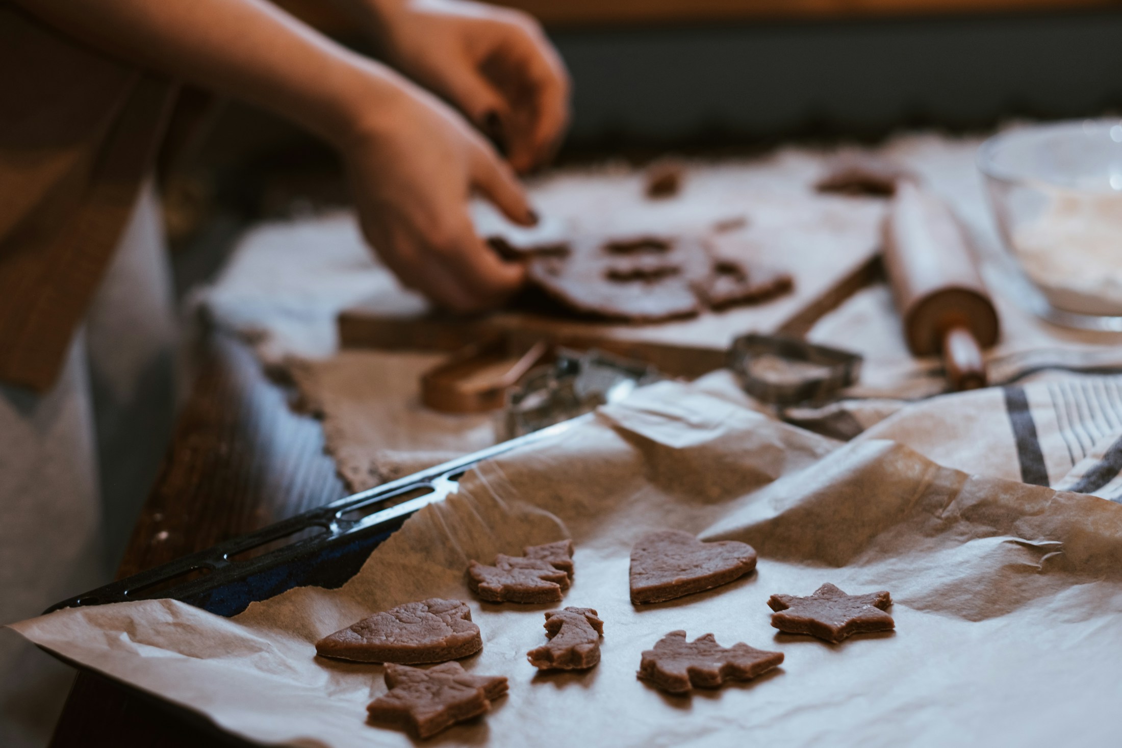 Hände stechen Weihnachtsplätzchen aus ausgerolltem Teig aus