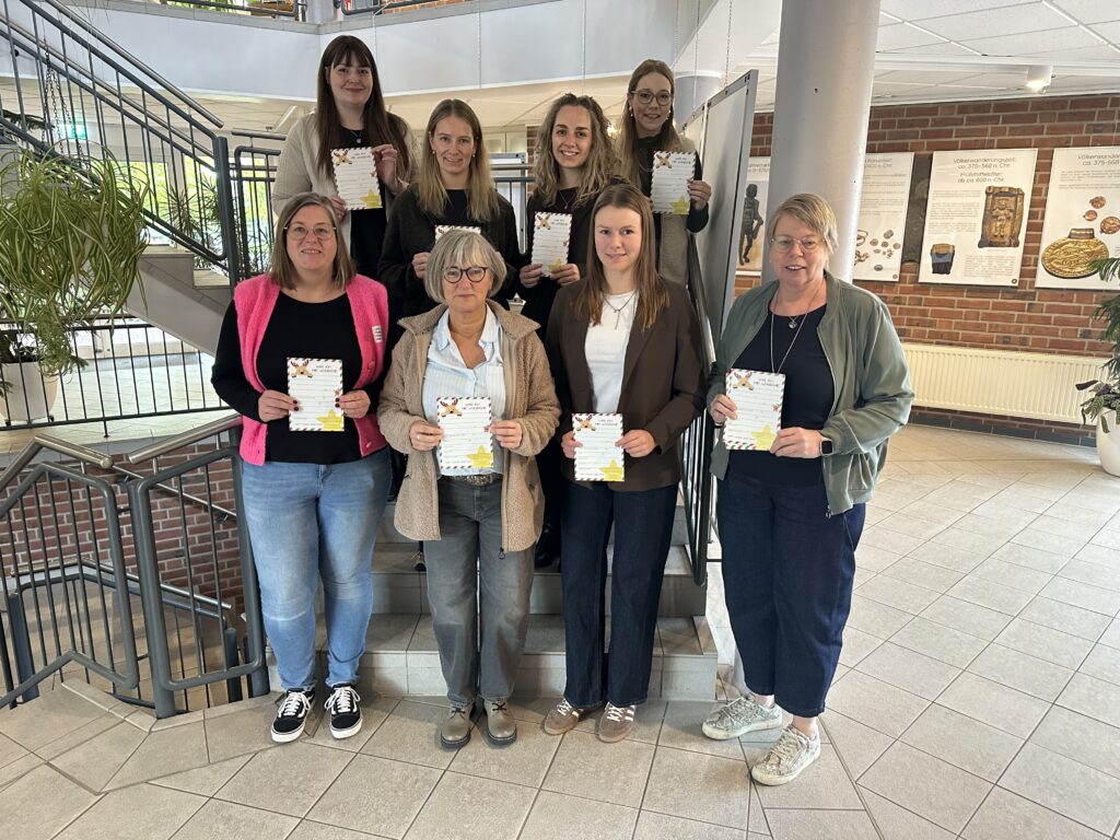 Acht Frauen stehen auf einer Treppe im Rathausfoyer und halten Wunschzettel in den Händen