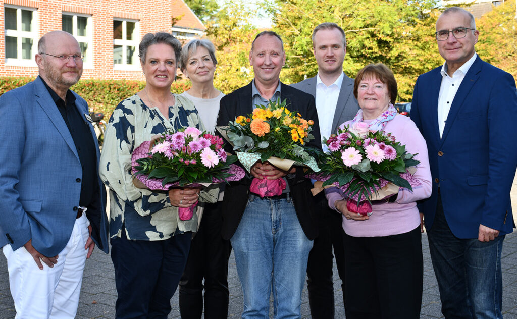 Erster Stadtrat Wigbert Grotjan mit den Dienstjubilaren Christine Bruns, Heinz-Georg Thoben und Ludmilla Repp, die Blumen halten, sowie Fachbereichsleitern und Personalrat im Ratssaal Cloppenburg