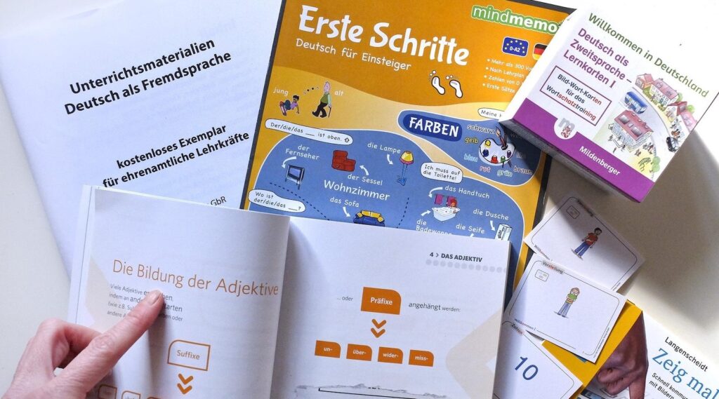 Lehrbücher, Lernposter und Bildkarten für Deutsch als Fremdsprache auf einem Tisch