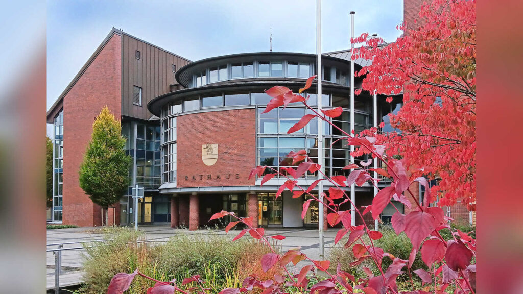 Rathaus der Stadt Cloppenburg mit herbstlich gefärbten Bäumen