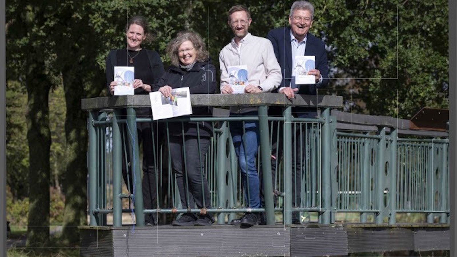 Vier Personen stehen mit Heften auf einer Brücke über die Hase an der Bifurkation in Melle-Gesmold