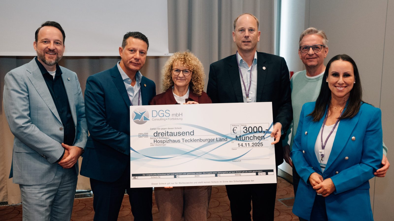 Gruppe von sechs Personen, die einen großen Scheck über 3000 Euro für das Hospizhaus Tecklenburger Land präsentieren.