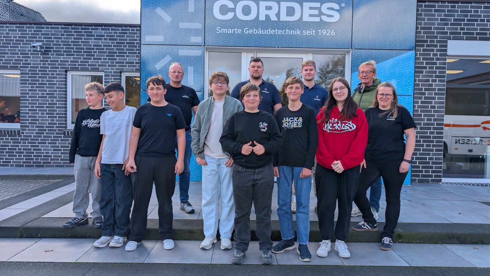 Gruppe aus Jugendlichen und Mitarbeitenden vor dem Firmengebäude von Cordes in Steinbild