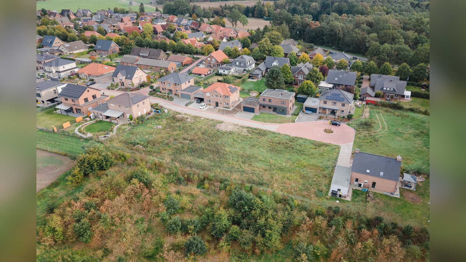 Luftaufnahme des Neubaugebiets in Kroge-Ehrendorf mit neuen Einfamilienhäusern und einer freien Wiese am Rand