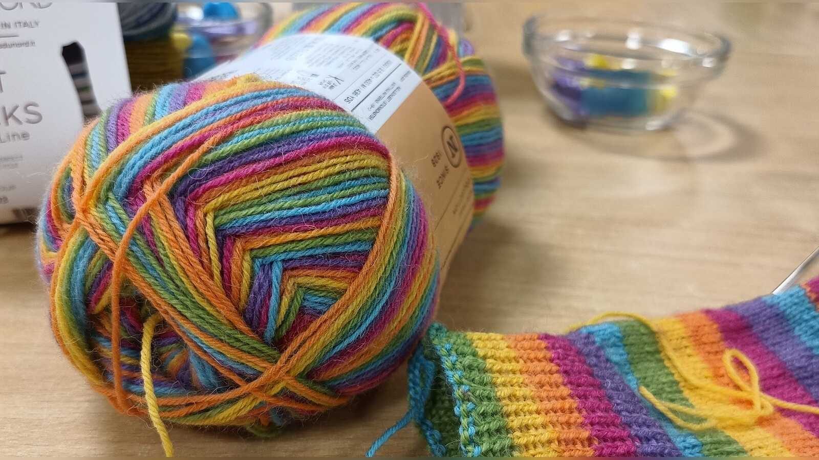 Hände beim Stricken mit Wolle und Stricknadeln