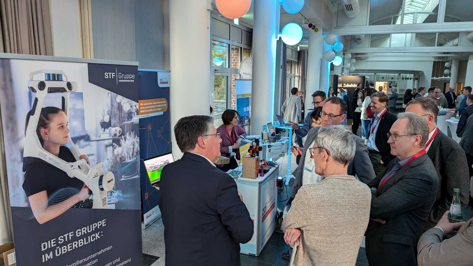 Besucherinnen und Besucher im Gespräch auf dem Markt der Möglichkeiten der Digitalkonferenz