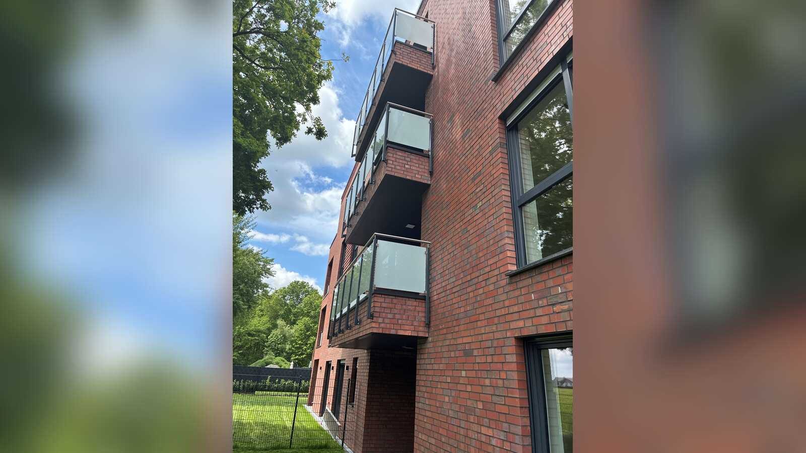 Neues Mehrfamilienhaus aus rotem Klinker mit Glasbalkonen in Senden