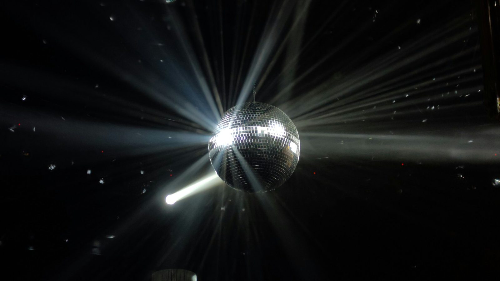 Discokugel wirft Lichtreflexe in einen dunklen Saal