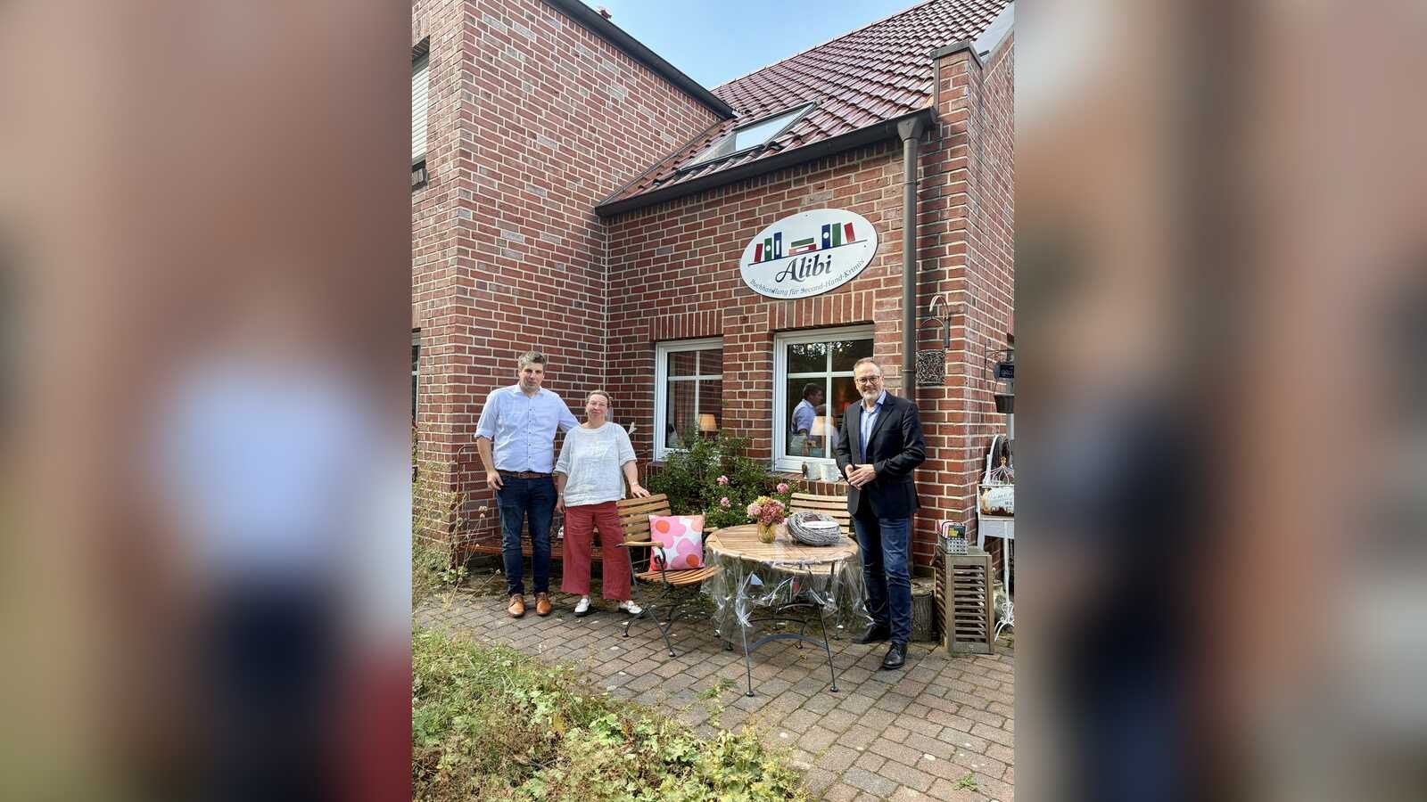 Bürgermeister Helmut Knurbein und Wirtschaftsförderer Alexander Kassner gratulieren Inhaberin Corinna Muss-Opitz in der Krimi-Buchhandlung Alibi in Meppen