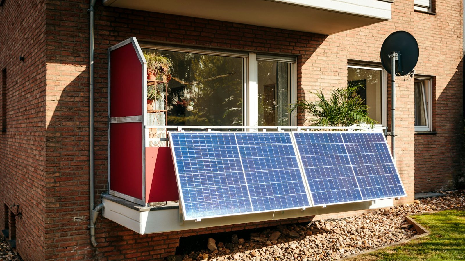 Kleines Solarmodul eines Balkonkraftwerks am Geländer eines Stadtbalkons