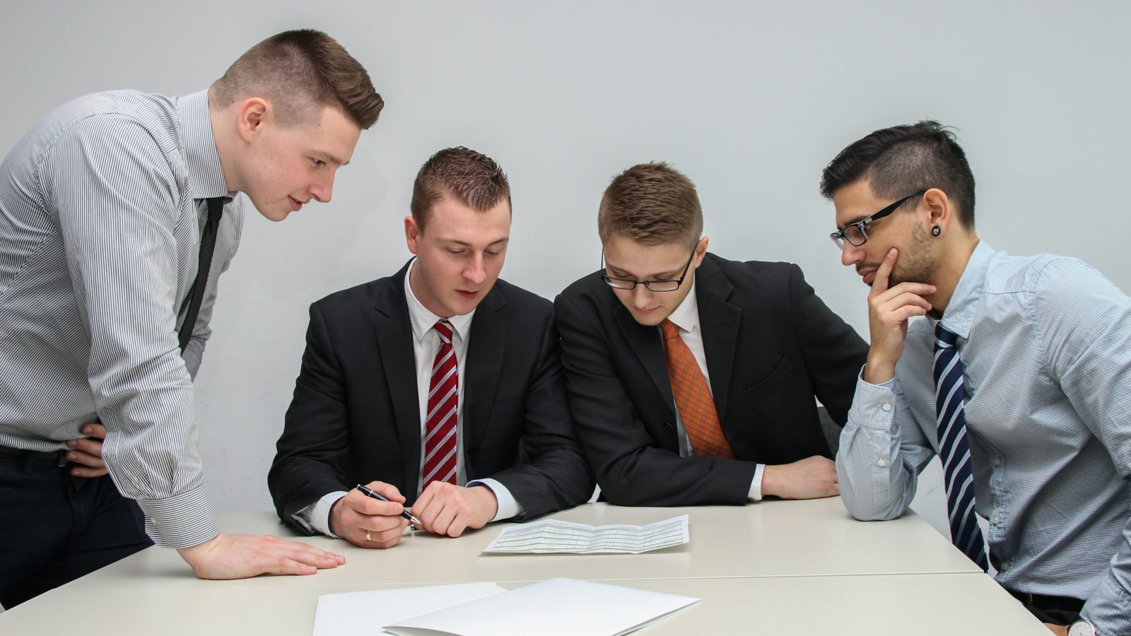 Mehrere Personen besprechen Unterlagen am Tisch (Symbolbild)