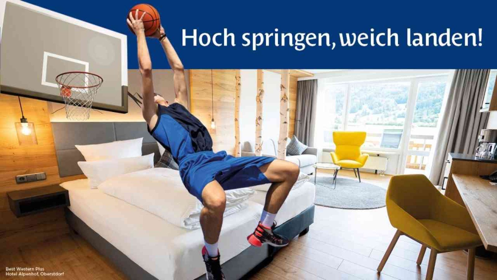 Basketballspieler springt hoch und landet sanft auf Hotelbett in modernem Zimmer. Komfortabler Aufenthalt garantiert.