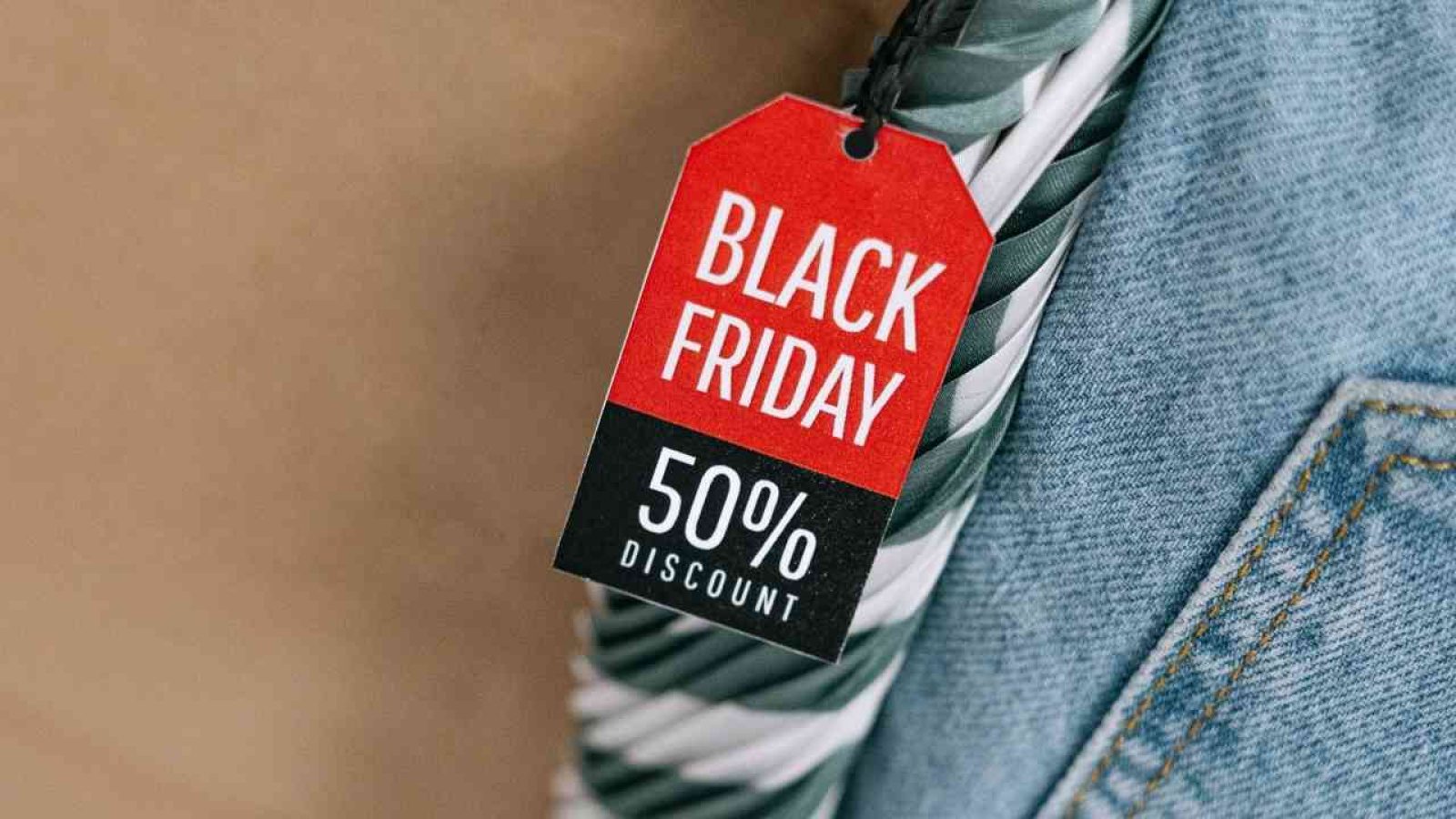 Ein rotes Preisschild mit der Aufschrift 'BLACK FRIDAY' und '50% DISCOUNT' hängt an einem Artikel.