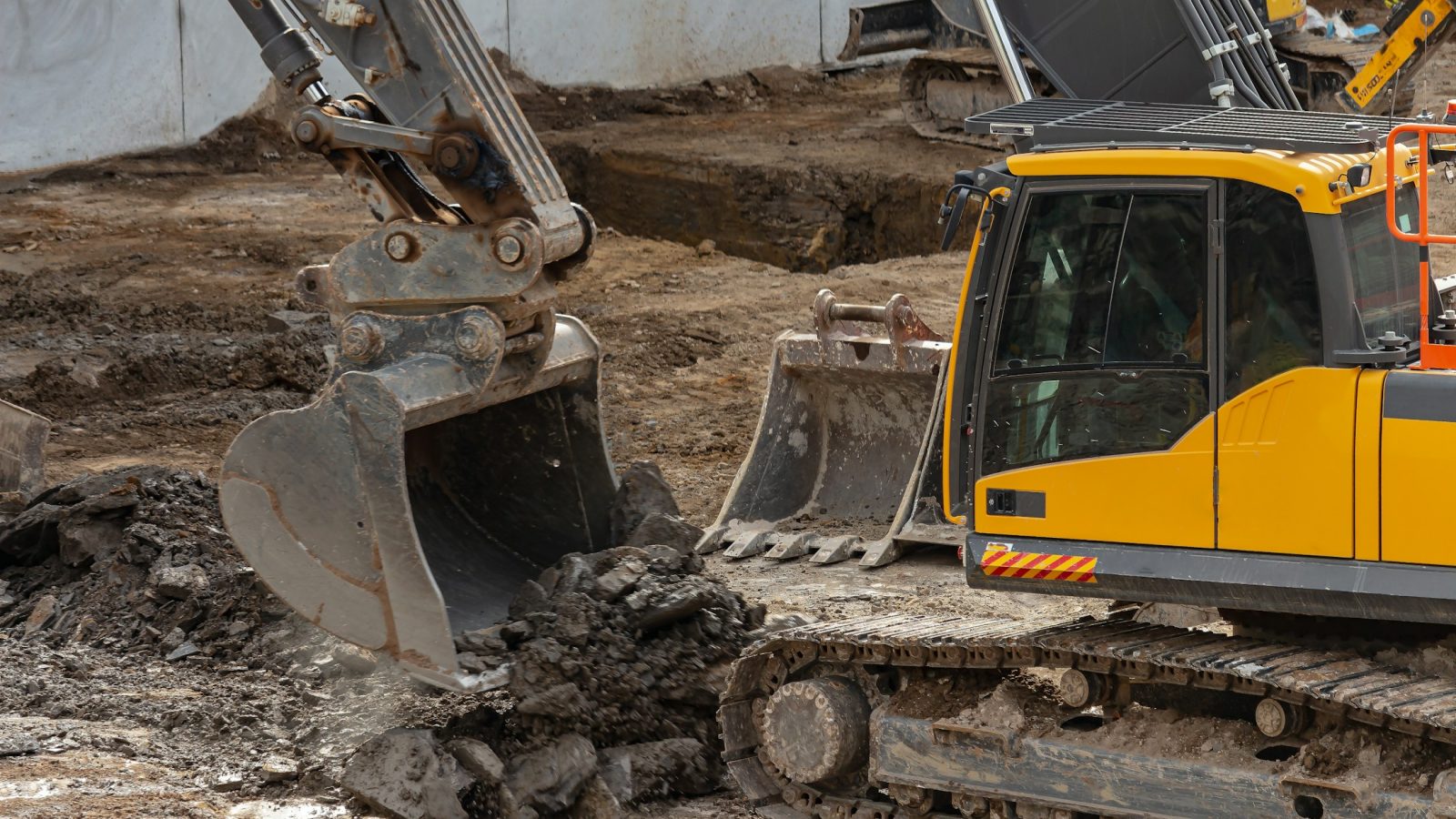Bagger hebt belasteten Boden auf einer Baustelle aus - Symbolbild fuer die Bodensanierung an der Feuerwache Nord in Nordhorn