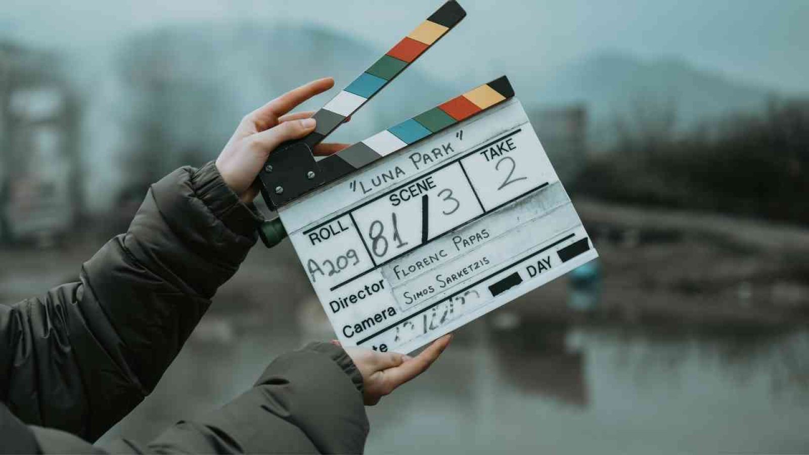 Hände halten eine Filmklappe mit den Angaben zu Szene, Regisseur und Kamera für den Film 'Luna Park'.