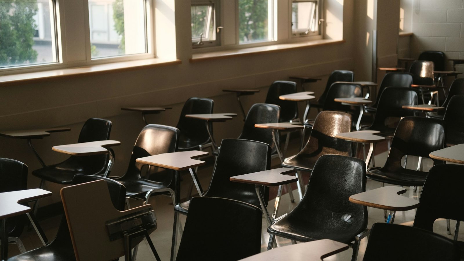 Leeres Klassenzimmer mit Tischen und Stühlen, Symbolbild zu Eingliederungshilfen und Schulbegleitung