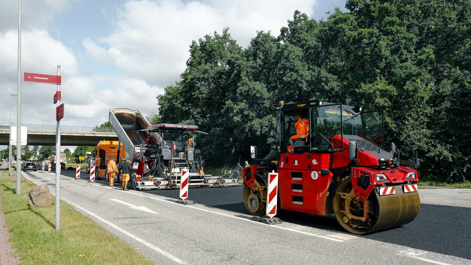 Asphaltfertiger und Straßenwalze bei der Erneuerung eines Fahrbahnbelags
