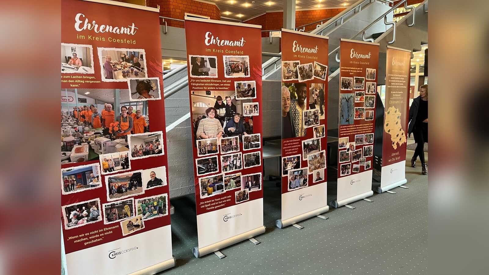 Besucherinnen und Besucher betrachten die Roll-ups der Wanderausstellung Gesichter des Ehrenamts