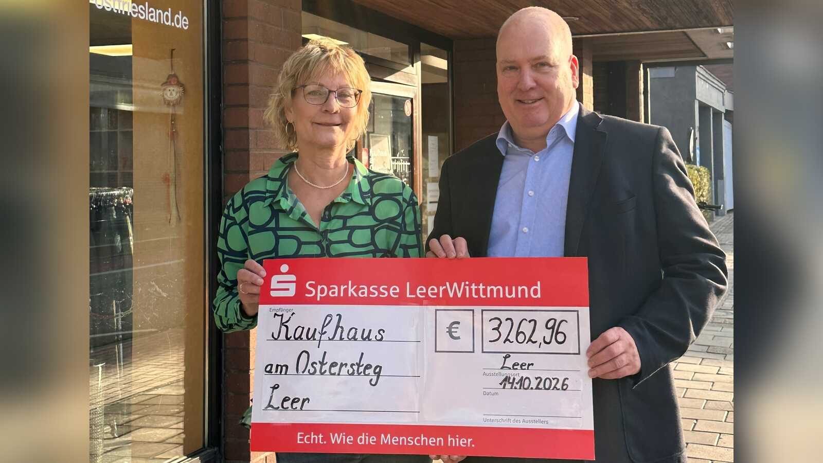 Bürgermeister Claus-Peter Horst übergibt einen symbolischen Scheck an Karola Blanke vom Sozialen Kaufhaus Leer