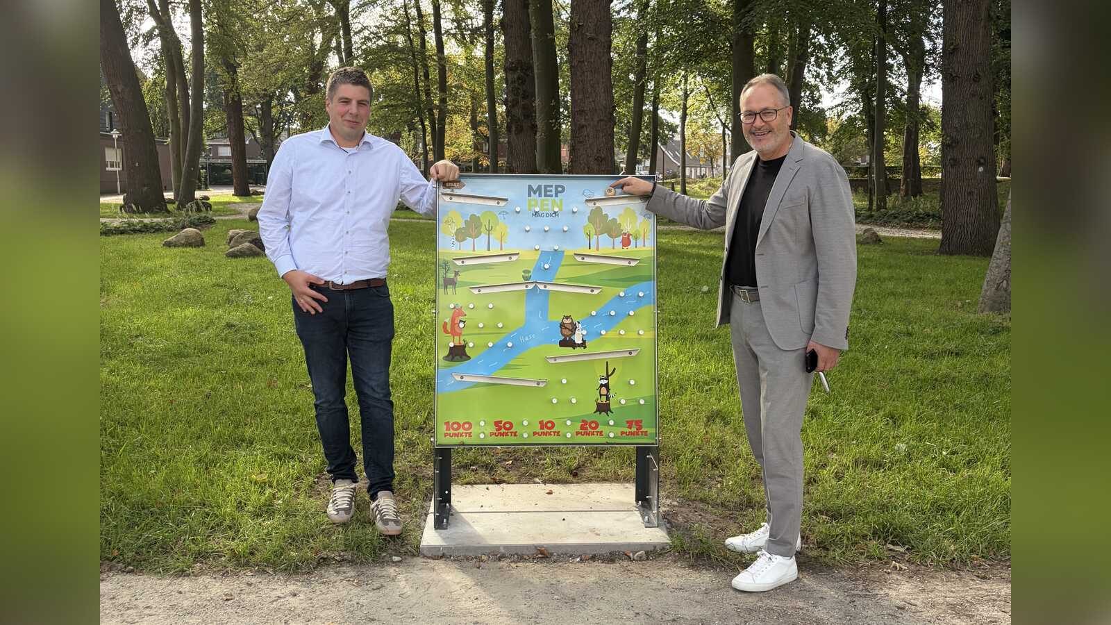 Wirtschaftsförderer Alexander Kassner und Bürgermeister Helmut Knurbein an einem der neuen Murmelspiele im Meppener Stadtpark
