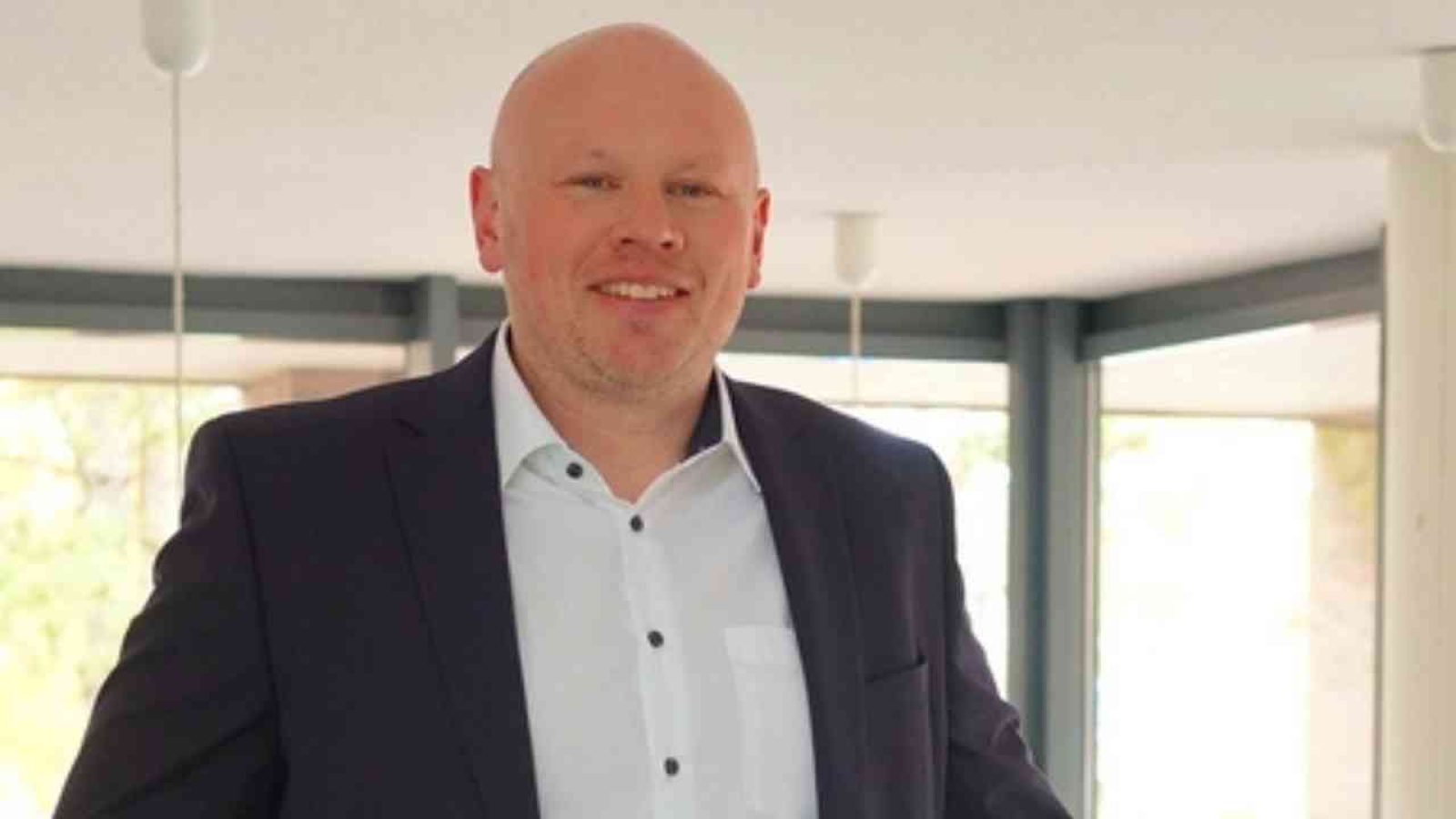 Jan Isger Doerre, der neue Leiter des Finanzamts Nordenham, lächelt in einem modernen Büro.
