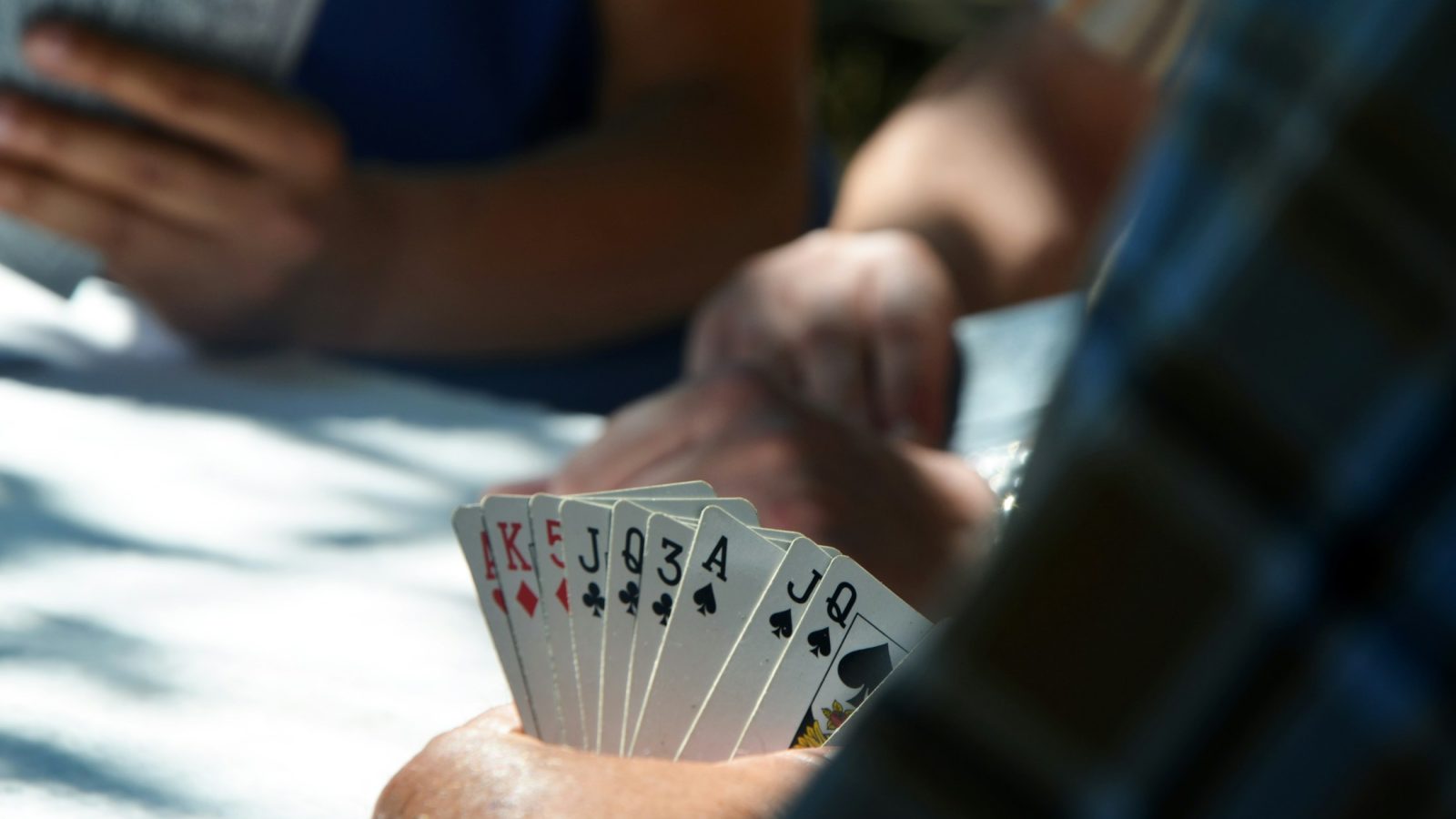 Menschen spielen Karten an einem Tisch