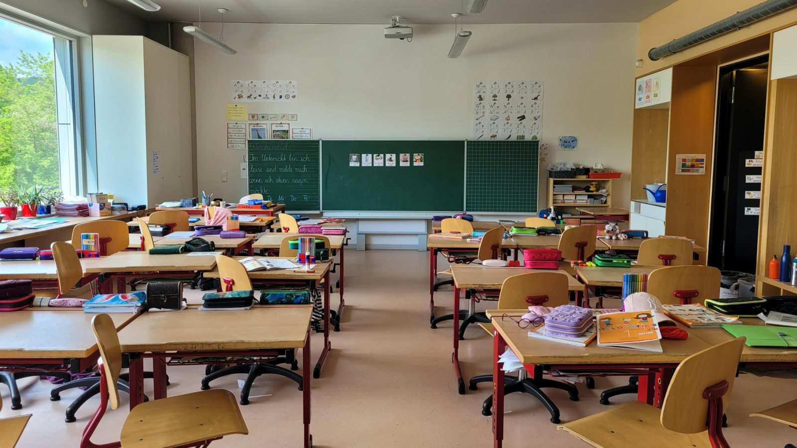 Leerer Klassenraum mit Tischreihen und Tafel