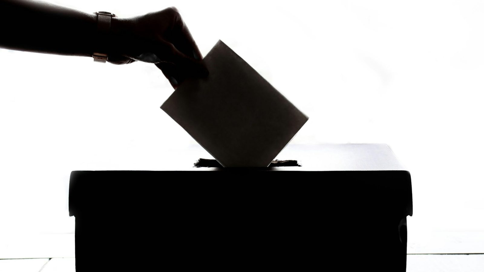 Hand wirft Stimmzettel in eine Wahlurne, Symbolbild zur Kommunalwahl