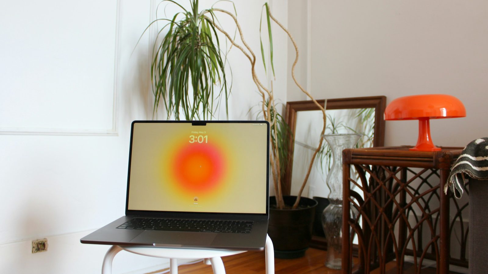Aufgeklappter Laptop auf einem Hocker in einem Wohnzimmer