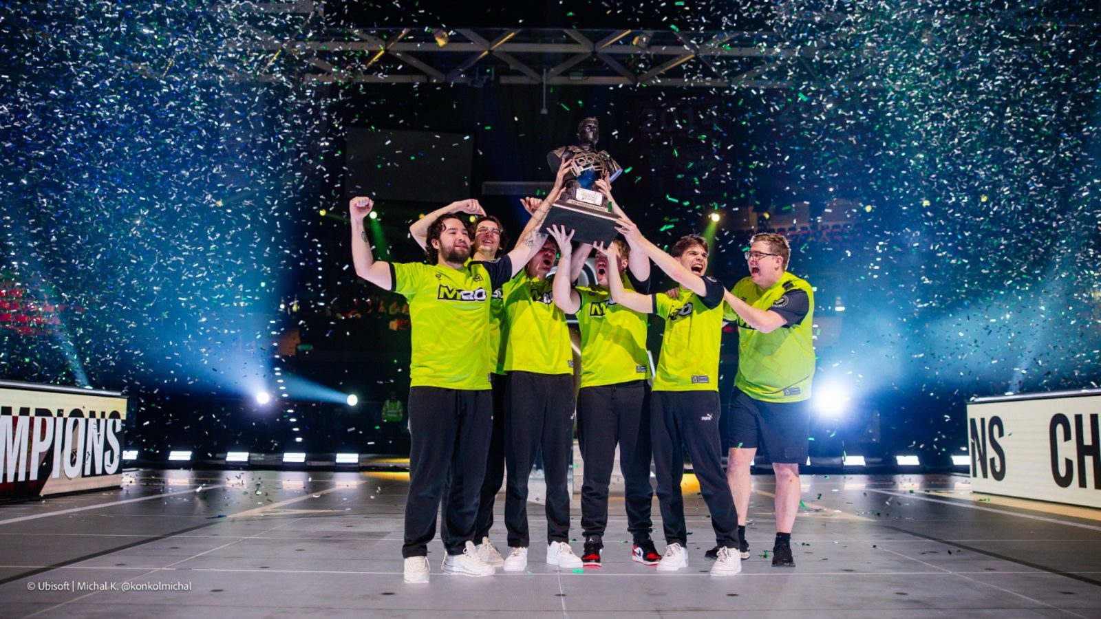 M80 E-Sport-Team feiert den Gewinn des BLAST R6 Munich Major mit dem Pokal in der Mitte auf der Bühne.