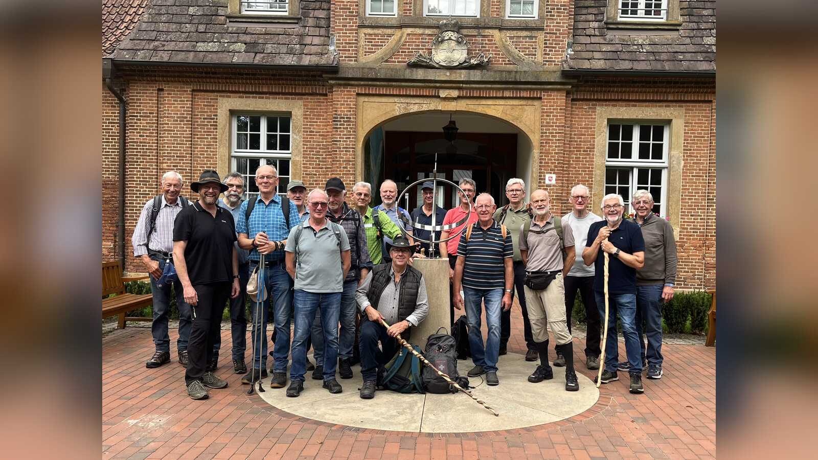 Gruppe von Männern mit Wanderstöcken vor dem Marstall Clemenswerth in Sögel