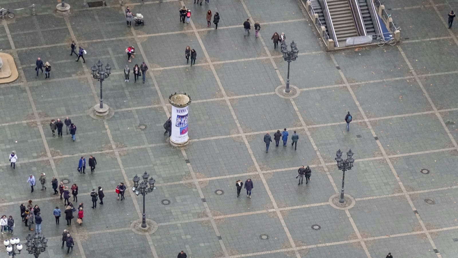 Menschen überqueren einen belebten Platz, Symbolbild für die Bevölkerungsstatistik