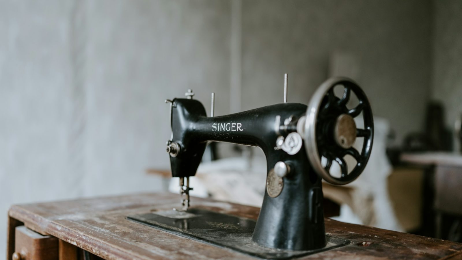 Naehmaschine mit Stoff auf einem Holztisch