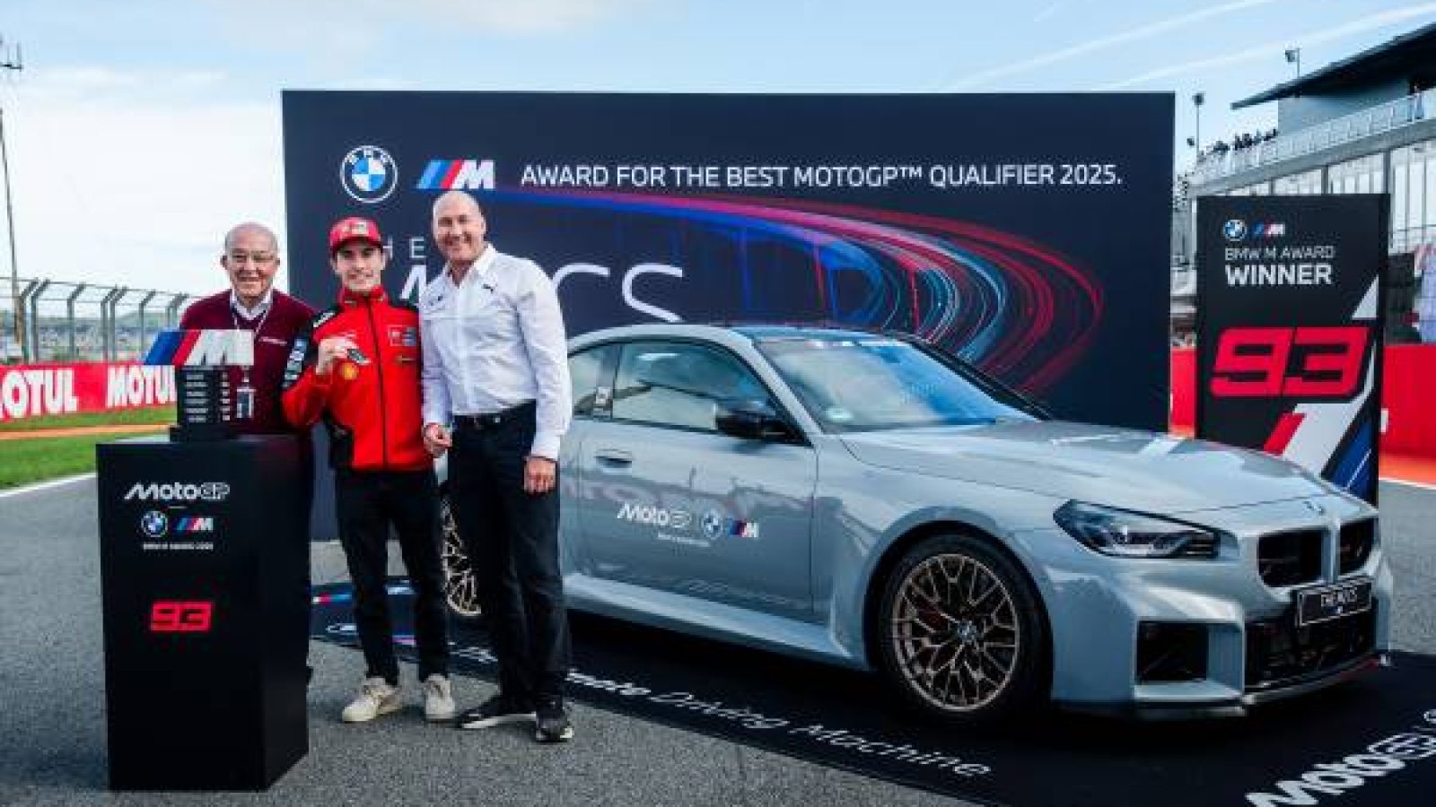 BMW M2 Coupé neben dem Gewinner des BMW M Award 2025 bei der MotoGP-Qualifikation.