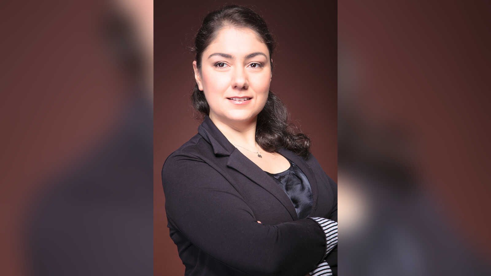 Porträt der Pianistin Susanna Kadzhoyan mit verschränkten Armen vor dunklem Hintergrund