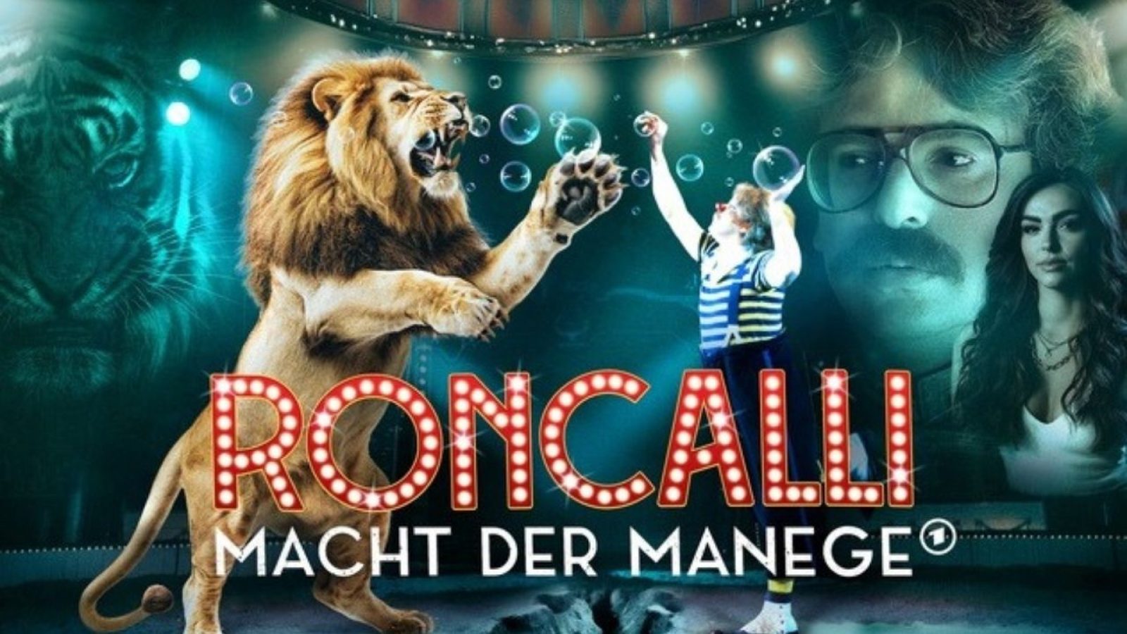 Löwe und Clown in der Roncalli-Zirkusshow, mit dramatischem Hintergrund und Scheinwerfern. Text: Roncalli – Macht der Manege.