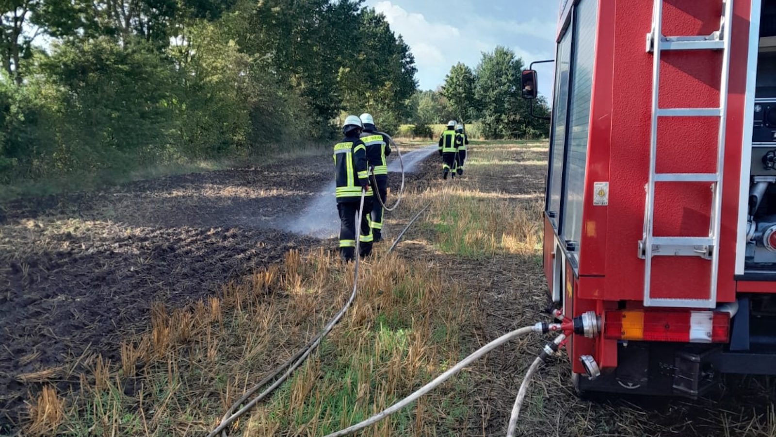 Löschfahrzeug setzt beim Pump-and-Roll-Verfahren Wasser gegen einen Vegetationsbrand ein