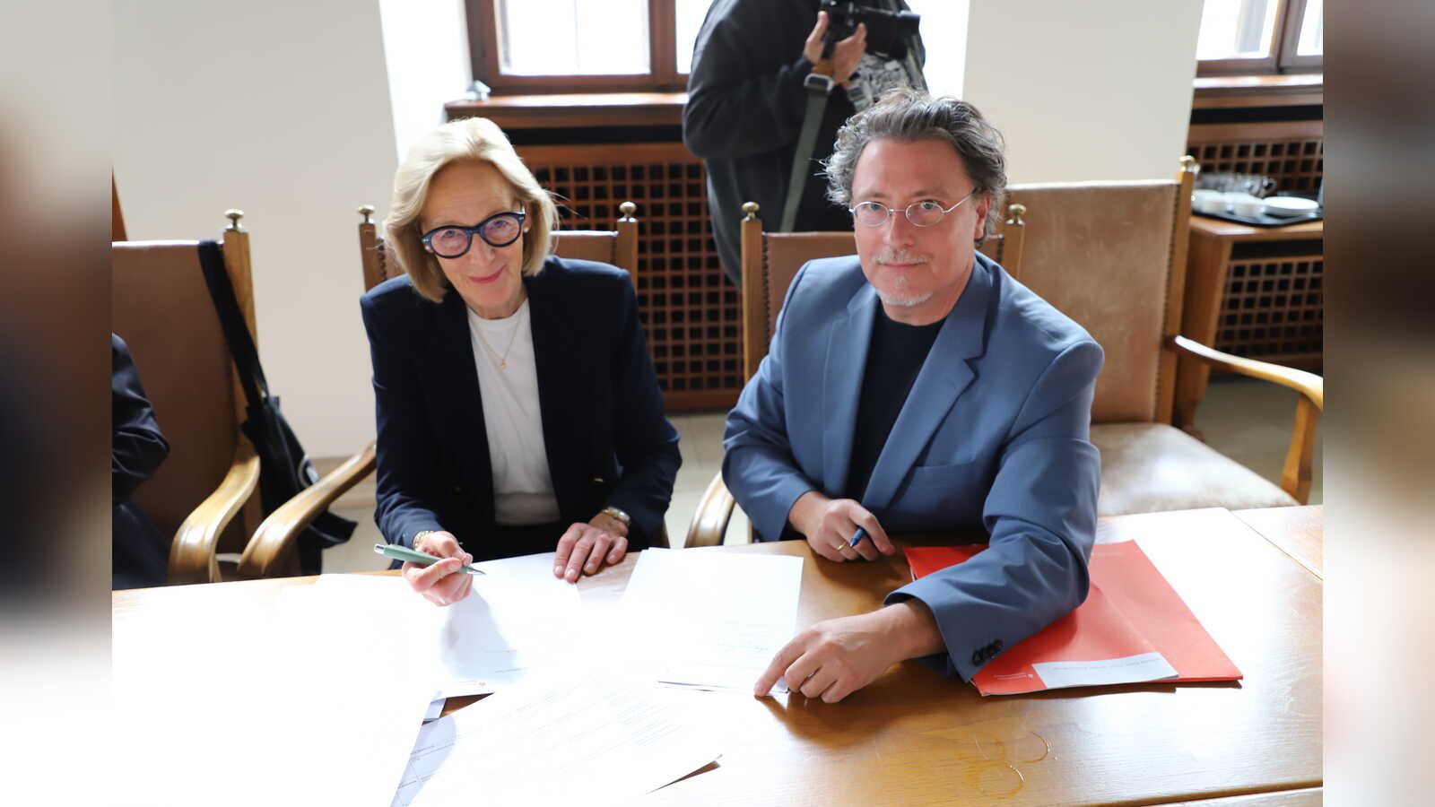 Dr. Ulrike Hamm, Vorsitzende des Museums- und Kunstvereins Osnabrück, und Dr. Johannes Janssen, Stiftungsdirektor der Niedersächsischen Sparkassenstiftung, unterzeichnen den Schenkungsvertrag
