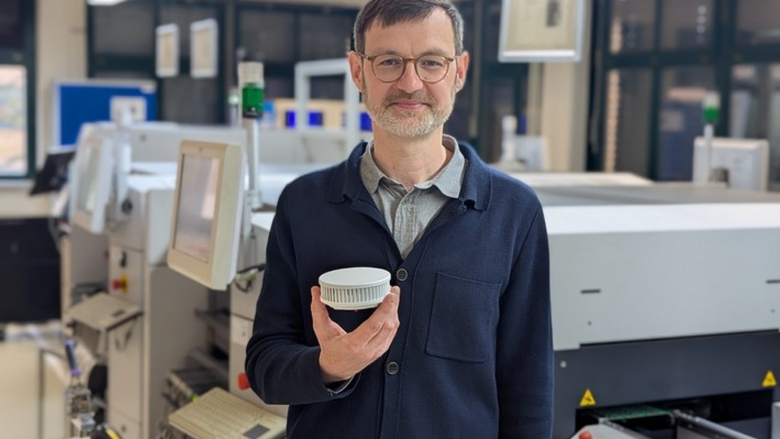 In der Berliner Produktion: Pyrexx-Geschäftsführer Sebastian Herre mit dem fehlerhaft getesteten Rauchmelder PX-1. Foto frei für redaktionelle Zwecke bei Quellennennung: Pyrexx / Weiterer Text über ots und www.presseportal.de/nr/182429 / Die Verwendung dieses Bildes für redaktionelle Zwecke ist unter Beachtung aller mitgeteilten Nutzungsbedingungen zulässig und dann auch honorarfrei. Veröffentlichung ausschließlich mit Bildrechte-Hinweis.