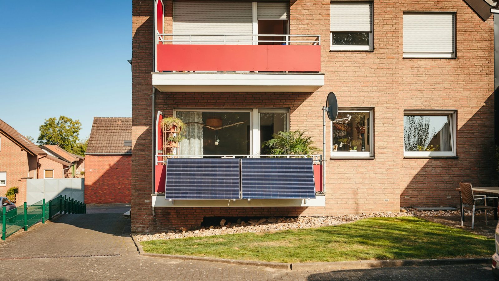 Solarmodul eines Balkonkraftwerks am Balkongeländer eines Mehrfamilienhauses